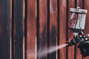 Man Airbrushing Paint on Fence